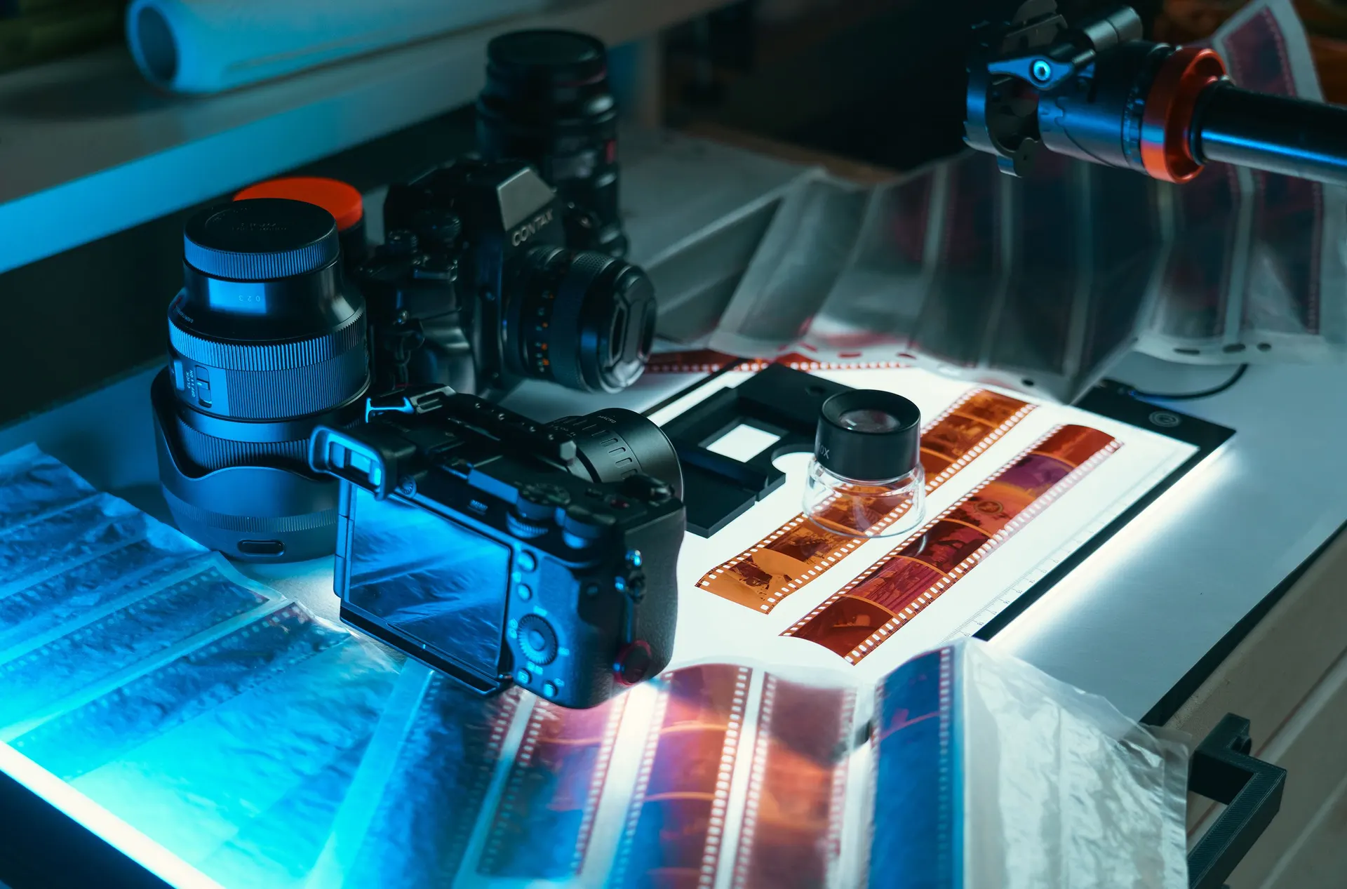 A photographer digitizing old film negatives on a lightbox with a camera